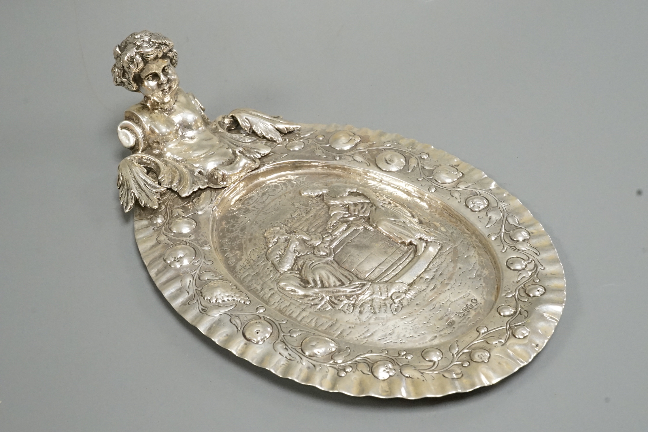 A late 19th century Hanau silver oval dish, with figural handle, import marks for David Bridge, London, 1891, 27cm, 12.4oz.